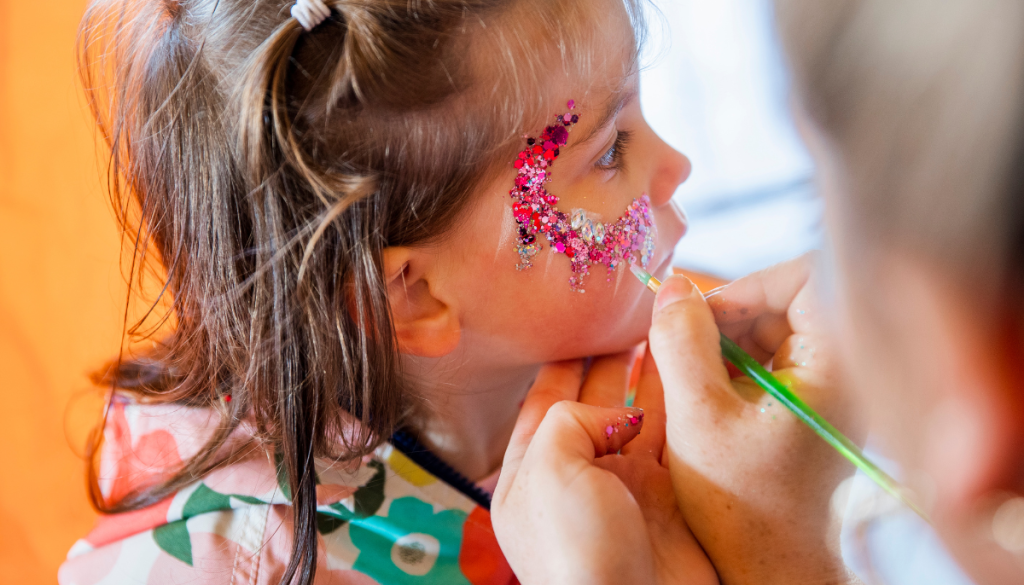 Insured face painter painting a child's face.