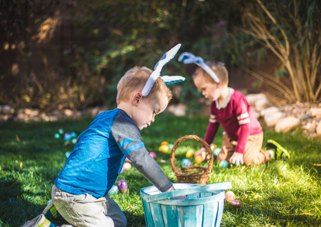 Two young boys taking part in an Easter egg hunt.