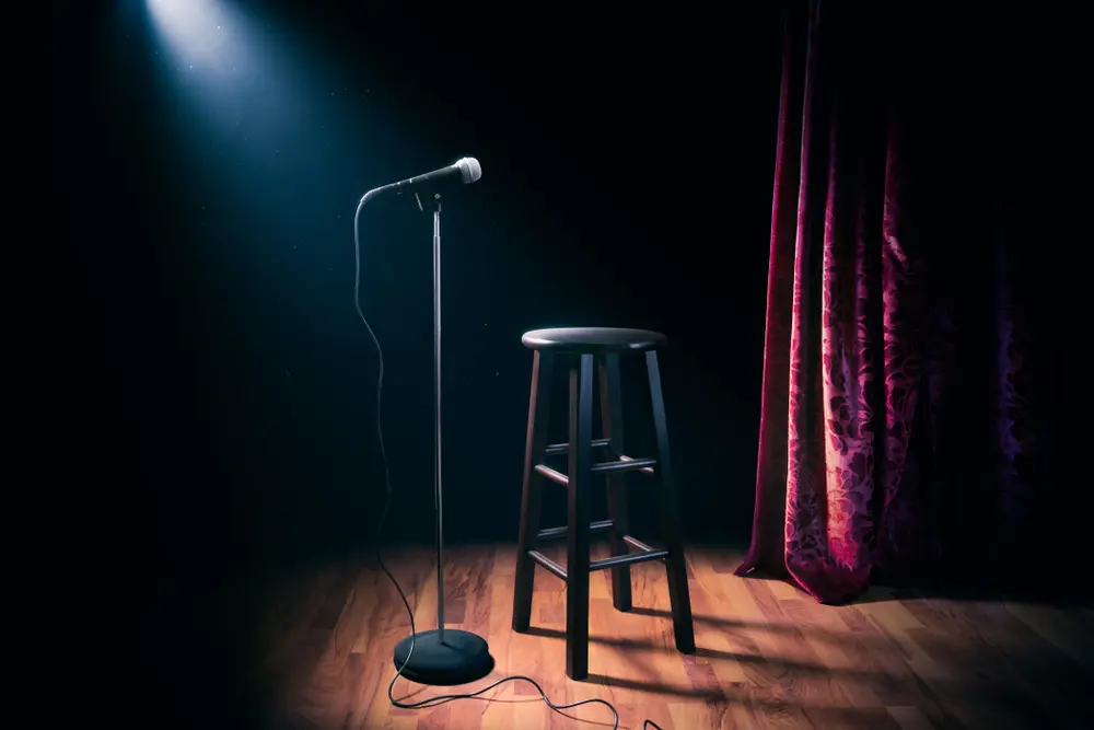 Empty stage with a microphone and stool illustrating Non-Appearance Insurance