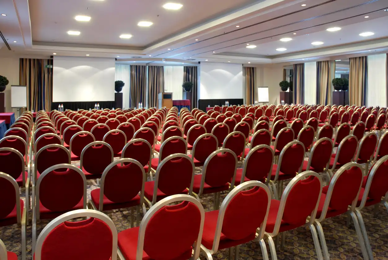 Conference room with rows of chairs facing a presentation screen